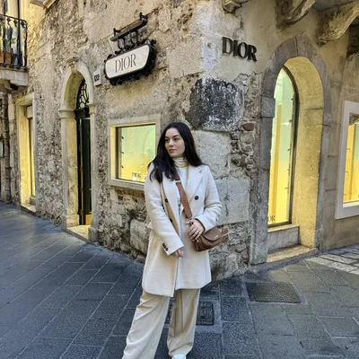 Carol Marcelino usando casaco e peças de inverno em uma rua europeia.